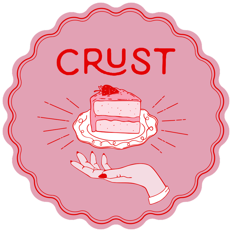 Crust Vegan Bakery logo, a pink circle with dark pink writing and design. text reads "Crust" above a slice of cake hovering above a hand